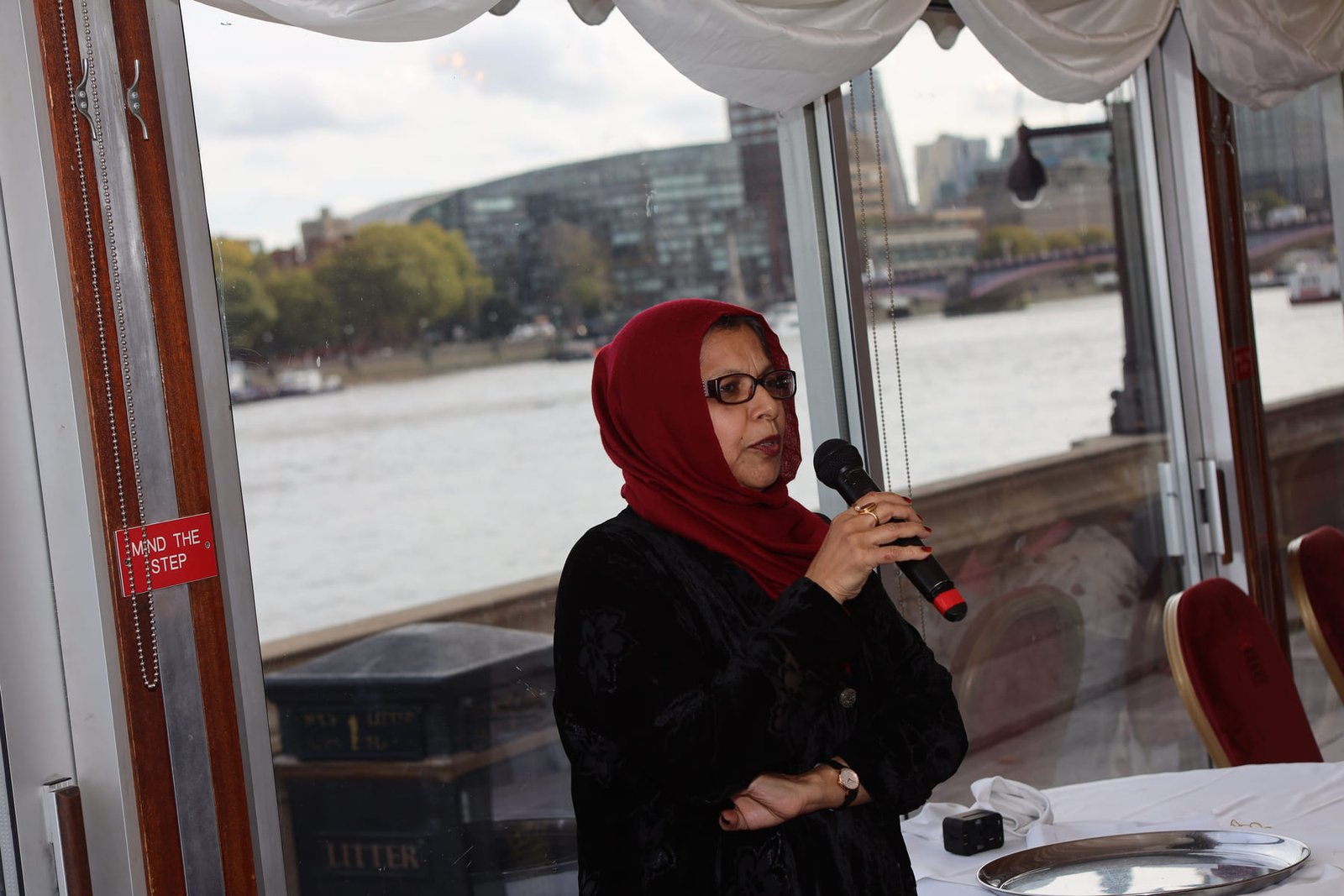 A delegate speaks beside the window overlooking the Thames